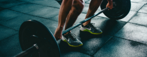 A man performing a deadlift with a barbell for the first time during a workout routine, focusing on lifting heavy weights and building strength.