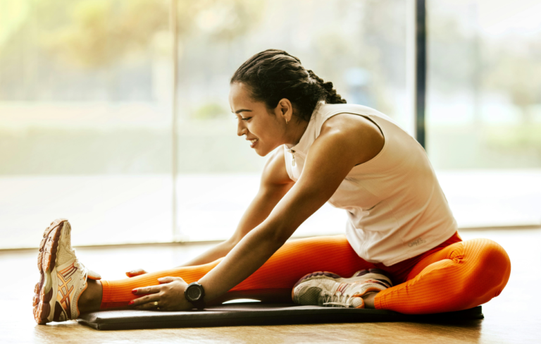 A person performing static stretching, highlighting the importance of flexibility and warm-up, cool-down routines in fitness.