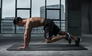 A man performing mountain climbers, which is an exercise of HIIT.