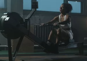 A woman rowing on a machine at the gym.