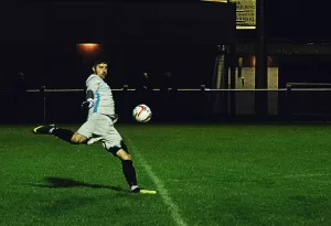 A male playing soccer and getting ready to kick the ball.